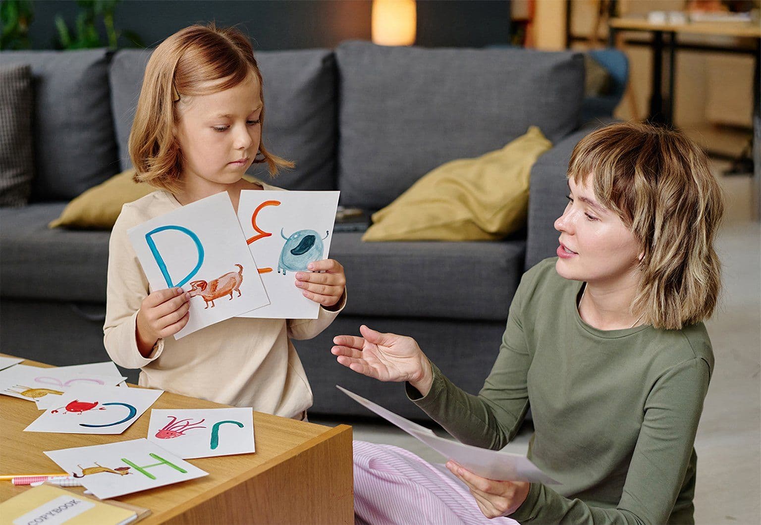 young-mom-her-kid-holding-colorful-cards-with-english-letters-studying-them-together (1) (2)